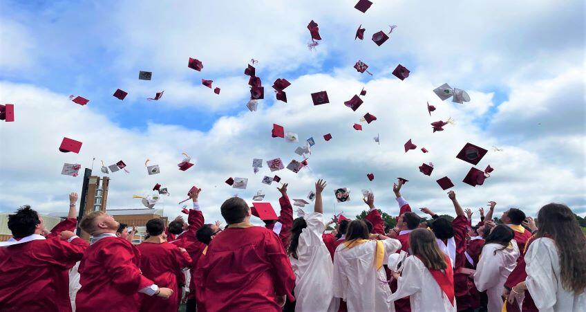 students throwing their graduation caps